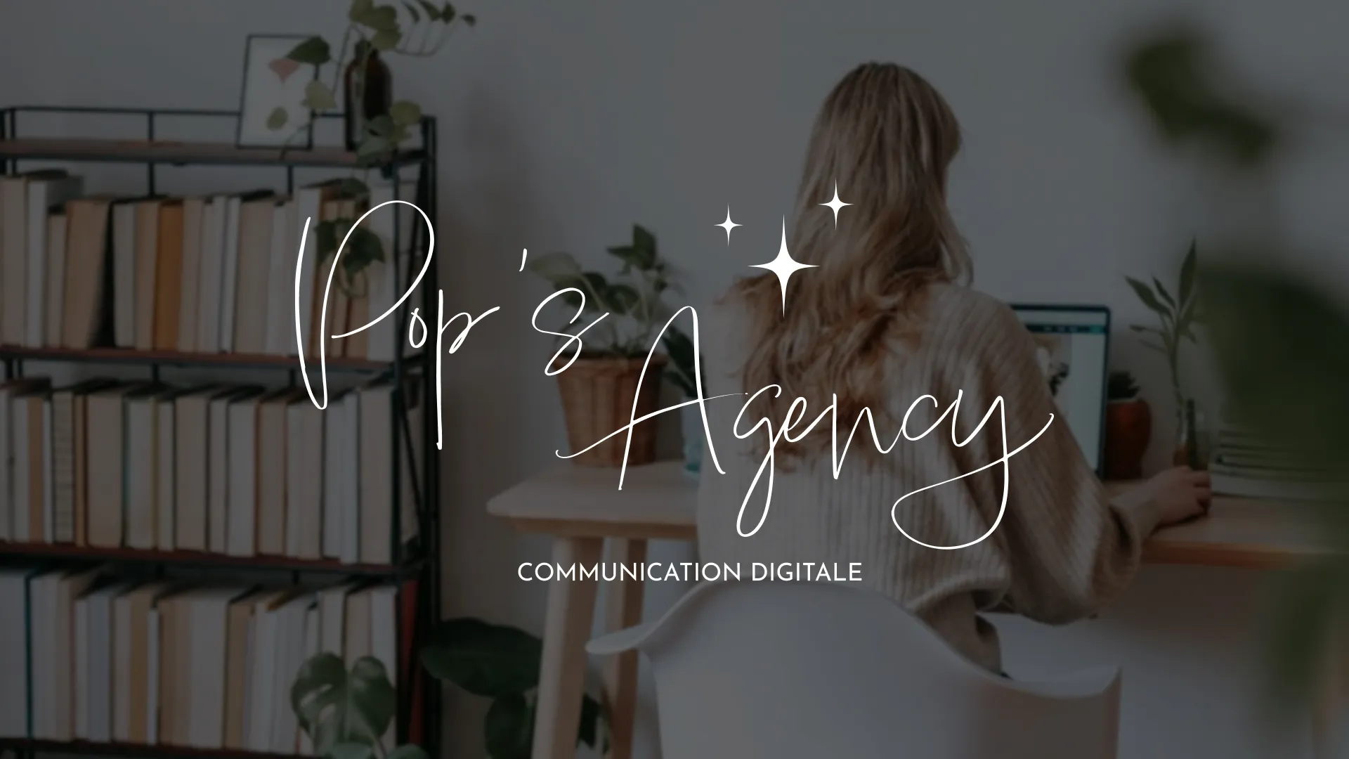 Logo blanc Pop’s Agency appliquée sur une photo d’espace de travail en communication digitale.